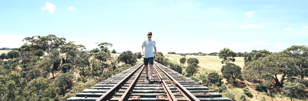 Guy On Railroad Tracks During The Day