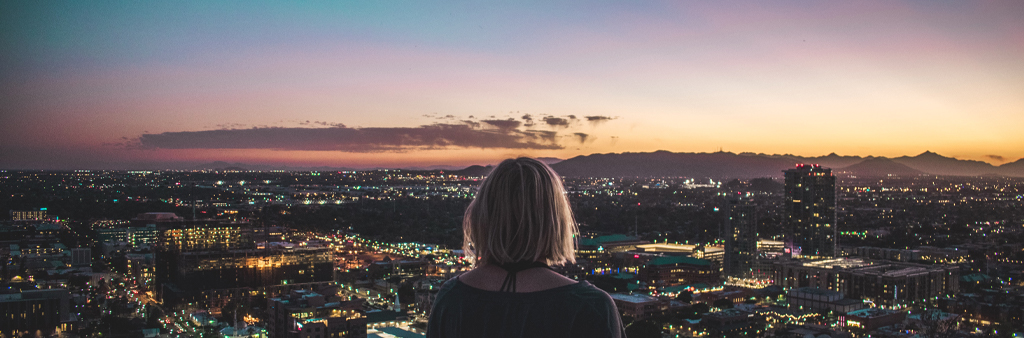 Woman Overlooking The City During Night Time