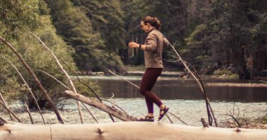Person Crossing The River On A Log