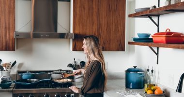 Woman Holding Brown Spatula Cooking Over Stove