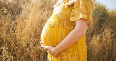 Pregnant Woman Wearing Yellow Dress Holding Pregnant Belly