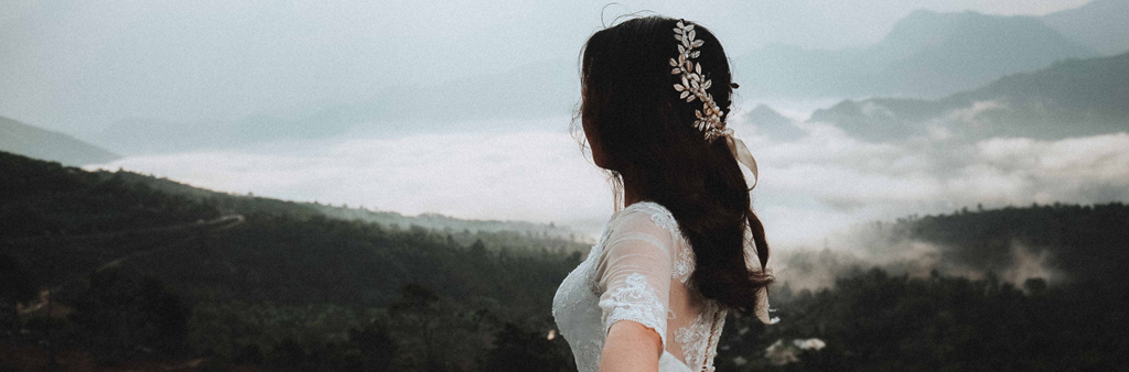 Woman In Wedding Dress Looking Toward Foggy Mountain