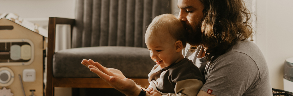 Dad With Long Hair Kissing Head Of Baby