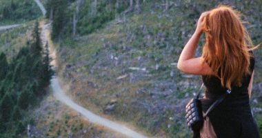 Woman Walking On A Dirt Path In A Field