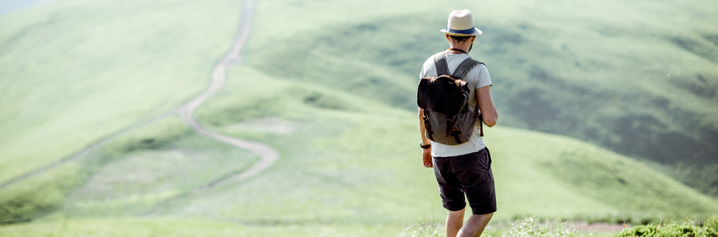 Man In Black Short And Backpack On Green Grass