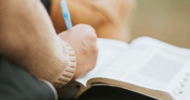 Person Writing On Book Page